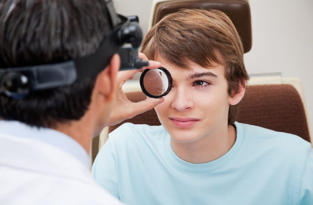 A teenage boy having his eye examined during a dilated eye exam