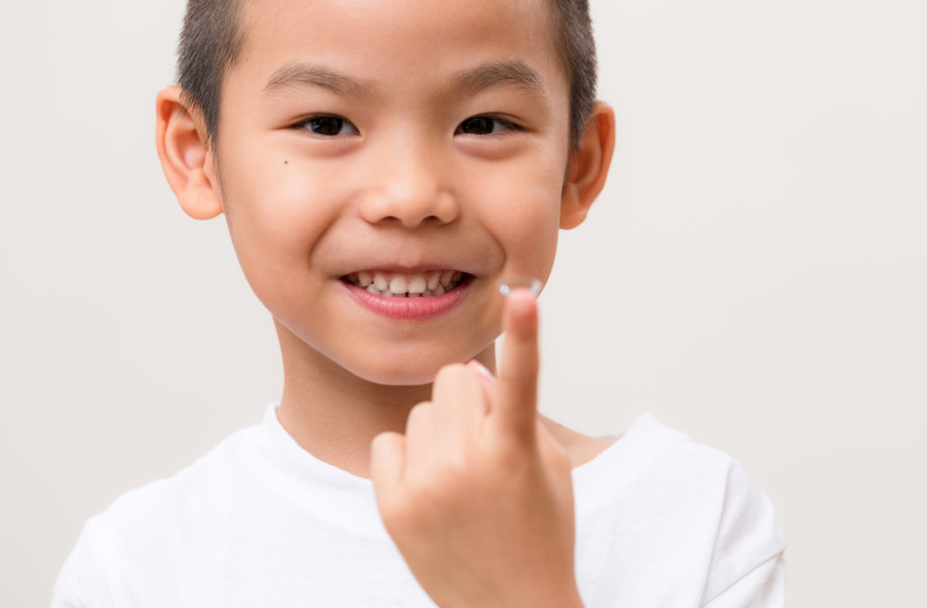 Young boy holding contact lens to help control myopia progression